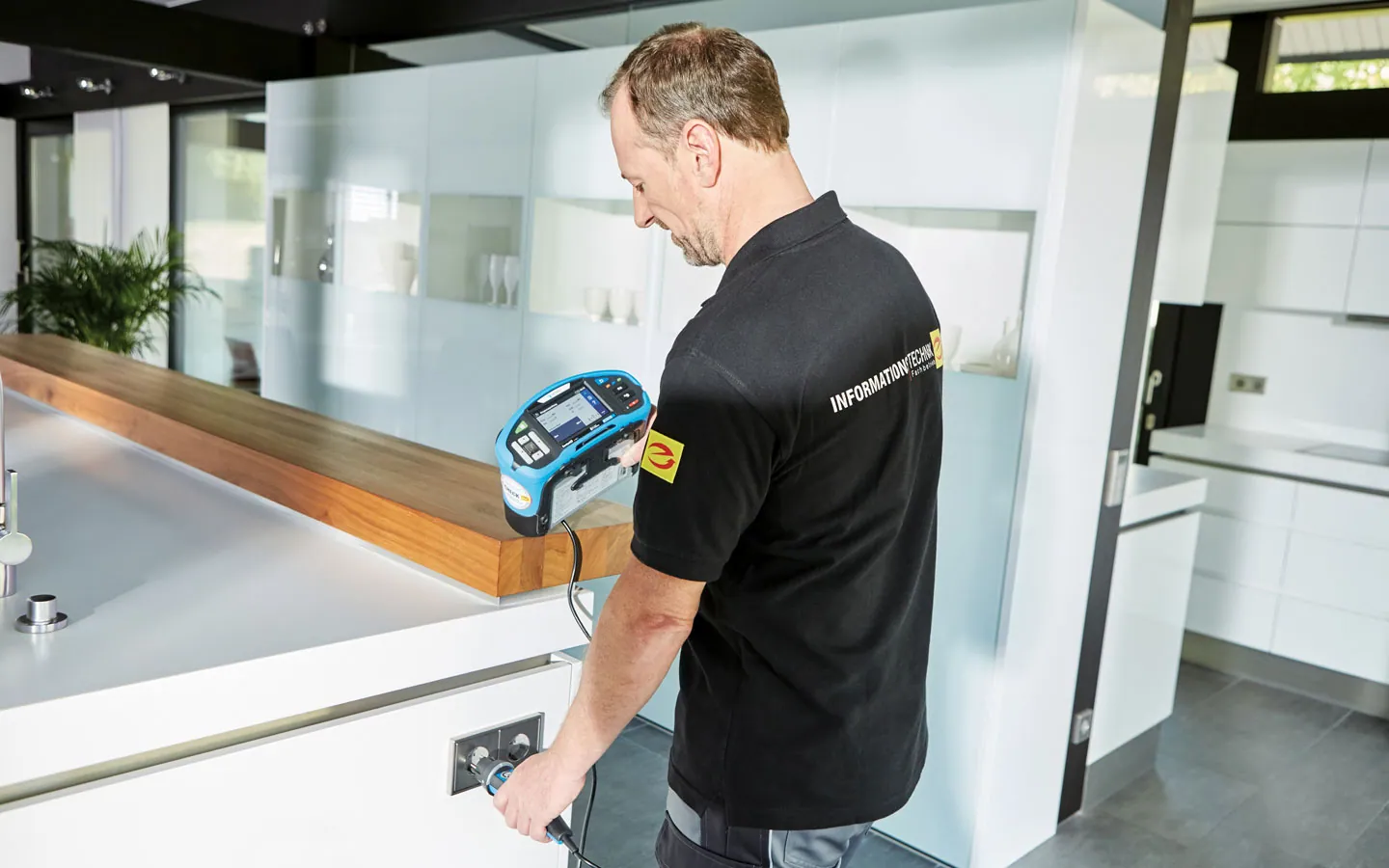E-CHECK - Mitarbeiter prüft die Steckdosen in der Küche &middot; B+B Mess- und Sicherheitstechnik